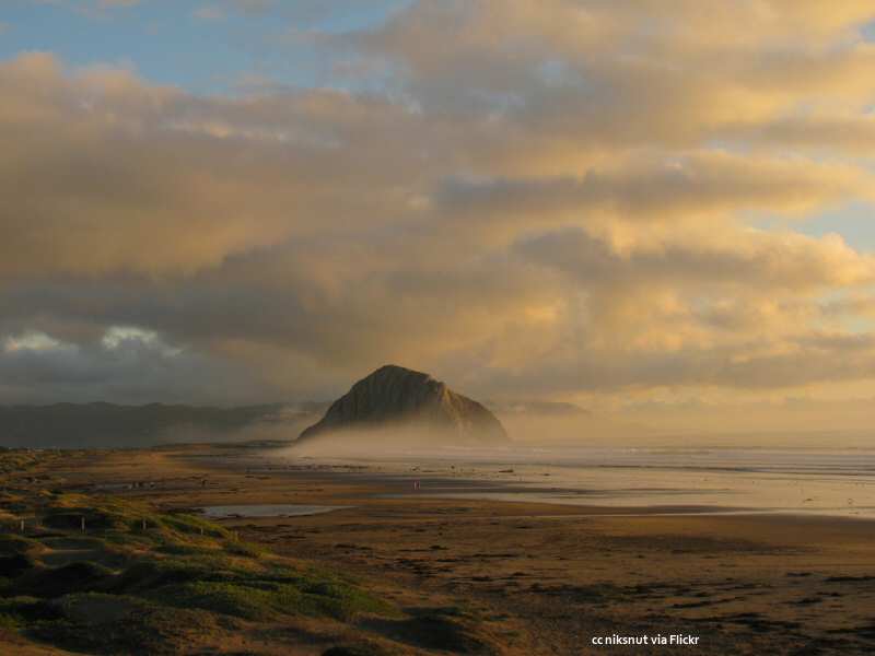 Light fog wraps around Morro Rock at sunset. Taken from North Point park.