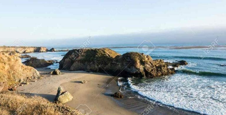 A large rock on a beach.